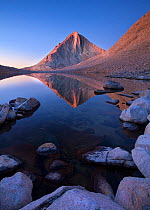 Dawn over Merriam Peak in the Royce Lakes region of the John Muir Wilderness Area, with reflections in the alpine lake, California, USA. September 2009