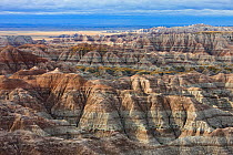 View of Badlands National Park, with shadows cast between mountain peaks, and sediment layers visible, South Dakota, USA. September 2009.