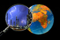 Lightning during thunderstorm above petrochemical industry seen through magnifying glass held against illuminated globe of the earth Digital composite