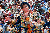 Portrait of female dancer performing in the streets with crowd of spectators at the Oruro Carnival. This is the biggest annual cultural event in Bolivia, with Morenada music and dancing originating fr...