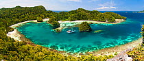 Panoramic view of live-aboard dive vessel at anchor in a limestone island lagoon, Uranie Island, Raja Ampat, West Papua, Indonesia.