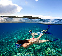 Couple free diving off Molokini Marine Preserve, Maui, Hawaii. Model released.