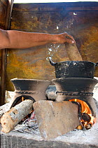 Woman cooking with wood efficient Bindi stove. Dry tropical forest of Colombia, South America
