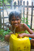 Portrait of young Colombian girl, collecting rainwater for future use, in the village of Los Limites. Colombia, South America. July 2008