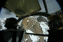 Rear view of pilot and director Vanessa Berlowitz  filming in the Karakoram Mountains, Himalayas, Pakistan. From Pakistani military helicopter for BBC series Planet Earth, April 2005