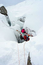 Film crew lowering camera into crevasse in Gorner glacier, near Zermatt in the Swiss Alps, Switzerland, for BBC Planet Earth series, Mountains episode, 2006