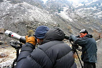 Local scouts and camerman Mark Smith searching for Snow leopard (Panthera uncia) in Chitral National Park, in the Hindu Kush, North West frontier, Pakistan. For BBC Planet Earth series, 2005.