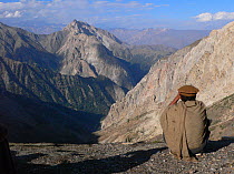 Local scout scanning mountain for Snow leopard (Panthera uncia) in the Hindu Kush, North West frontier, Pakistan. Filming of BBC Planet Earth series, Mountains episode, 2005