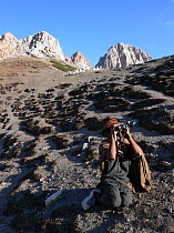 Local scout scanning mountain for Snow leopard (Panthera uncia) in the Hindu Kush, North West frontier, Pakistan. Filming of BBC Planet Earth series, Mountains episode, 2005