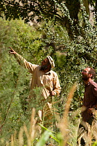 Cameraman Mark Smith working alongside local tracker, searching for Snow leopard (Panthera uncia) whilst on location for BBC Planet Earth series, Mountains episode, 2005