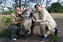 Presenters Mark Carwardine and Stephen Fry with Northern White rhinoceros (Ceratotherium simum) on location for television programme 'Last Chance to See: Return of the Rhino', Ol Pejeta Conservancy, K...