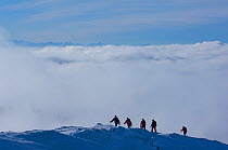 Landscape of mountains in winter, with walkers crossing peaks, in the Jura region, Switzerland. January 2009