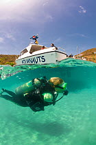 Split level view of scuba diver with PR Aquanauts boat in Grenada, Caribbean. May 2009. Property released and diver model released.
