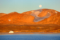 Sunrise with full moon in North Arm fjord, with colourful coastline of Baffin Island, Nunavut, Canada,  August 2010
