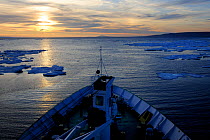 View across the bow of the Lyubov Orlova ship,  moving through pack ice  at dawn, off the coast of Devon Island. Nunavut, Canada,  August 2010