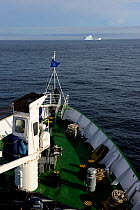 View from deck of a cruise ship, with iceberg on horizon, cruising along Baffin Island, Nunavut, Canada, August 2010