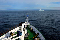 View from deck of a cruise ship, with iceberg on horizon, cruising along Baffin Island, Nunavut, Canada, August 2010