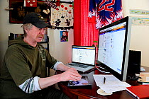 Portrait of Joey Carpenter, half Inuit, half Irish, working on his computer at home. Sachs harbour village, Banks Island, Northwest Territories, Canada, August 2010