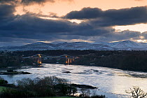 Menai Suspension Bridge, view at dawn from Anglesey towards Snowdonia, Wales, January 2010.