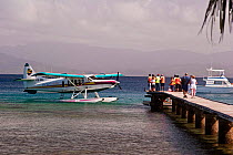 Seaplane pulling up at jetty with passengers waiting. Jean-Michel Cousteau Fiji Islands Resort, Savusavu, Fiji.