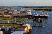 Boats and industrial development along the road to Grand Isle in the Mississippi River delta. Plaquemines Parish, Louisiana, USA, July 2010.