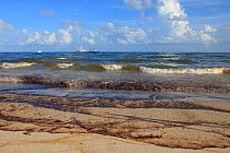 Waves washing oil ashore from the BP Deepwater Horizon oil leak. Baldwin County, Alabama, USA, June 2010.