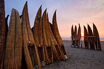 Upturned canoes (caballitos) owned by the Fishermen of Totora, on Pimentel beach at sunset. Chiclayo. Peru November 2009