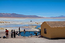 Tourist at hotsprings, in the Salar de Chalviri salt flats, Altiplano, Bolivia. February 2009.