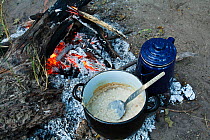 Porridge cooking on a camp fire, camping in the Okavango Delta, Botswana, March 2009