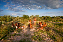 Kalahari bushmen, family group preparing food in the bush, rainy season, Central Kalahari Desert, Botswana, March 2009