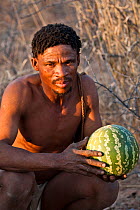 Kalahari bushmen, Qhaikgao with a desert melon harvested in the bush, Central Kalahari Desert , Botswana, August 2008