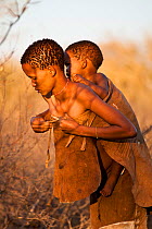 Kalahari bushmen, mother carrying her child on her back, Central Kalahari Desert, Botswana, August 2008