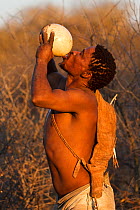 Qhaikgao, a Kalahari bushman, drinking water from an ostrich's egg during the dry season. Kalahari Desert, Botswana, August 2008