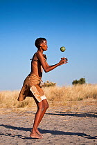 Kalahari bushmen, woman playing with melon, Central Kalahari Desert, Botswana, August 2008