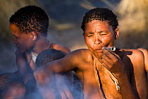 Kalahari bushmen, woman 'Qobo' smoking local tobacco pipe, Central Kalahari Desert, Botswana, August 2008
