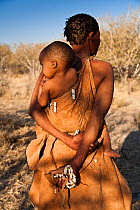 Kalahari bushmen, woman carrying child on her back, Central Kalahari Desert, Botswana, August 2008