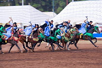 Traditionally dressed Berber warriors, mounted on Barb and Arab Barb horses, galloping into battle with guns pointed down during the Fantasia in Dar Es Salam, Morocco, June 2010