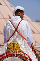 Back of a tradionally dressed Berber warrior riding his Arab Barb stallion during the Fantasia, in Dar Es Salam, Morocco, June 2010
