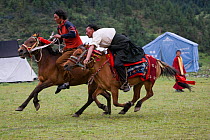 Two Khampa warriors race on their Tibetan horses during the horse festival, near Huangyan, in the Garze Tibetan Autonomous Prefecture in the Sichuan Province, China, June 2010