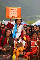 The winner of the endurance race and his Tibetan horse are covered with scarves, during the horse festival, near Huangyan, in the Garze Tibetan Autonomous Prefecture in the Sichuan Province, China, Ju...
