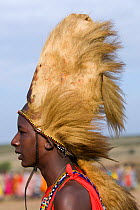 Maasai warrior wearing lion mane headdress Masai Mara Reserve, Kenya, East Africa, August 2008