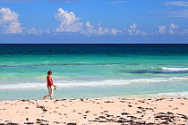Woman walking on beach near Tulum, Yucatan, Mexico, October 2006. Model released.