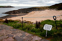 Notice advising visitors to Inner Farne not to go on the beach to avoid disturbing a colony of nesting Arctic terns (Sterna paradisaea), Farne Islands, Northumberland, England, July 2010.
