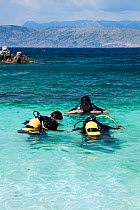 Dive instructor and trainees beginning their dive off Kanoni Beach, northern Corfu, Greece, June 2010.