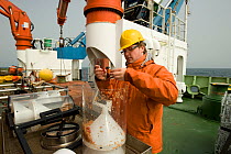 Grant Duffy sorting a sample from an Amphipod trap onboard the James Cook research vessel, Atlantic ocean, June 2010