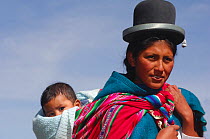 Portrait of Aymara mother and her baby, standing near the edge of Lake Titicaca, Bolivia, South America 2008