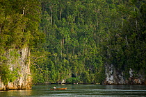Fisherman in canoes at the cliff lined passage entrance to Mayalibit Bay. West Papua, Indonesia, April 2007