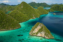 Aerial view of a boat making its way through the Wayag Islands, an uninhabited group of uplifted limestone (karst) islands, NW of Waigeo Island. West Papua, Indonesia, April 2007
