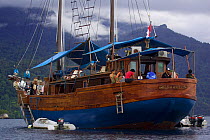 Crew relaxing on the stern of ship Shakti on a GEO Expedition at anchor in Triton Bay. West Papua, Indonesia, April 2007