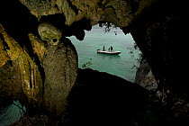 Skull cave with a human skull embedded in the wall, with Triton bay and diving tender visible in background. Raja Ampat, West Papua, Indonesia, May 2007